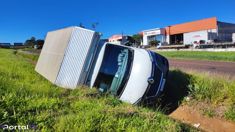 Caminhão carregado com perfumaria tomba após cair em canaleta de rodovia; ninguém se feriu